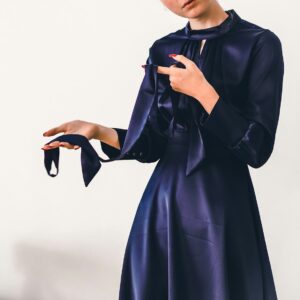 woman in black long sleeve dress holding black leather handbag