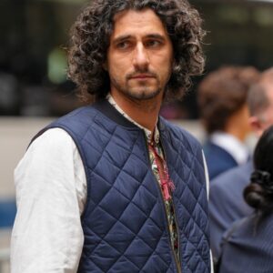 Man with curly hair wearing a vest