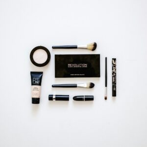 cosmetics and brushes on white panel